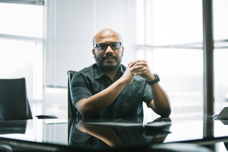 Bimal Viswanath seated at a conference room table