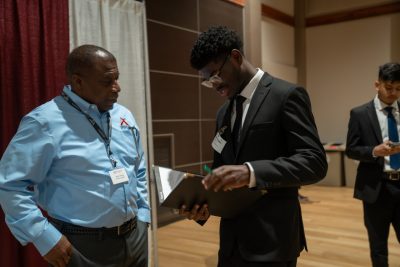 student talks with employer at career fair.