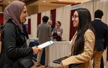 Computer science students interact with company reps at career fair. 