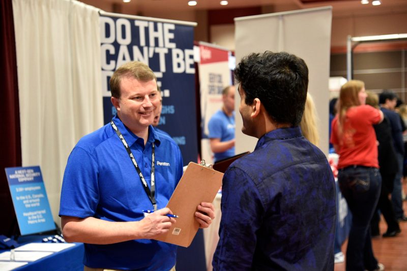 Peraton's  Director of Blacksburg Operations Greg Caufman ('95, electrical engineering) talks with Virginia Tech computer science students at the  CS|Source spring 2020 career fair.