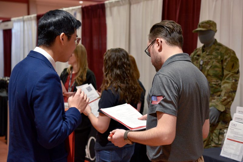 A representative of CACI's university programs team talks with Virginia Tech computer science students at the CS|Source spring 2020 career fair in February, prior to the COVID-19 pandemic.